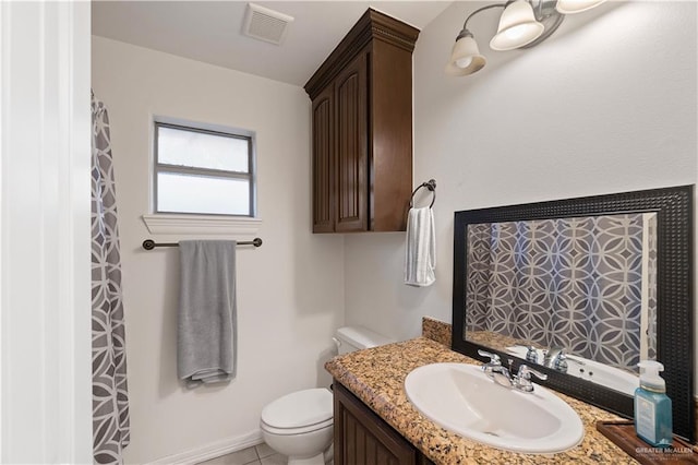 bathroom with tile patterned flooring, vanity, and toilet