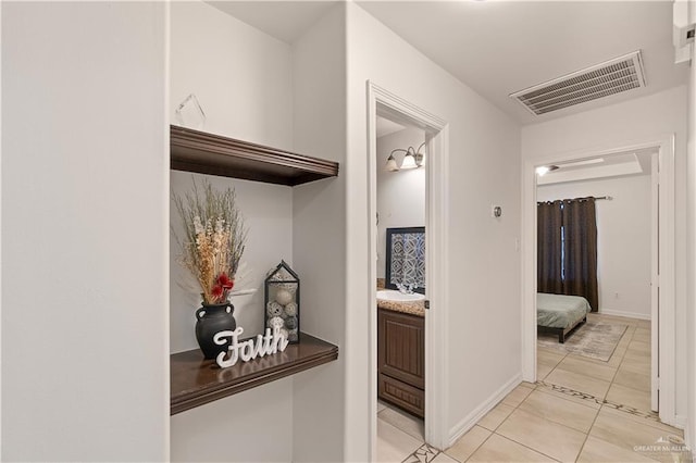 corridor featuring light tile patterned flooring and sink