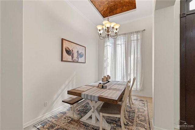 dining area featuring a tray ceiling, crown molding, plenty of natural light, and a chandelier