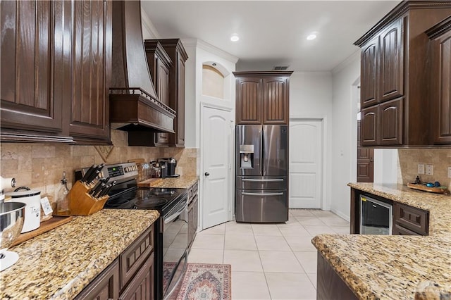 kitchen featuring dark brown cabinetry, light tile patterned floors, and stainless steel appliances