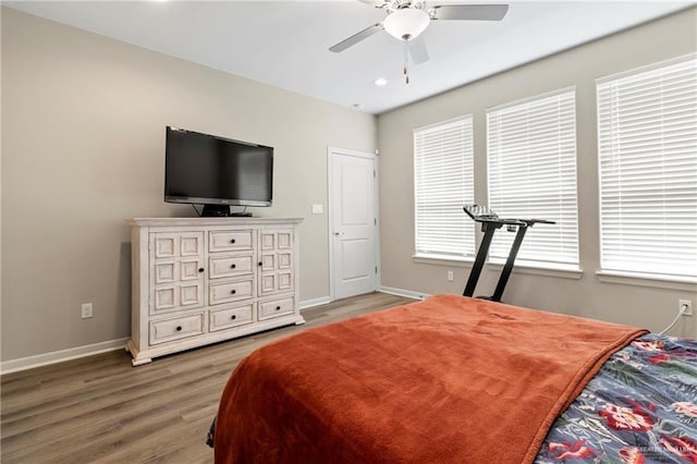 bedroom with baseboards, wood finished floors, and a ceiling fan