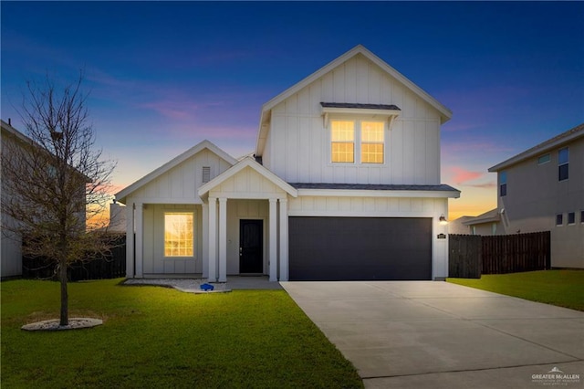 modern inspired farmhouse featuring fence, driveway, an attached garage, a lawn, and board and batten siding