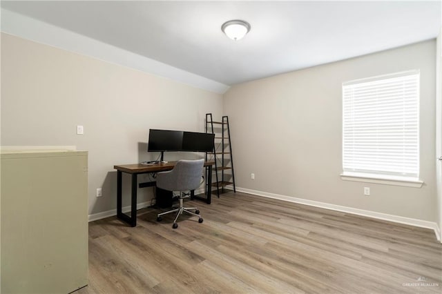 office area with vaulted ceiling, wood finished floors, and baseboards