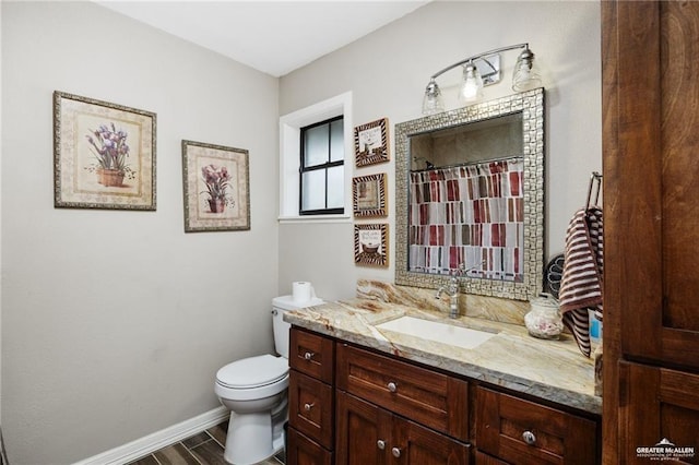 bathroom with toilet, a shower with curtain, baseboards, and vanity