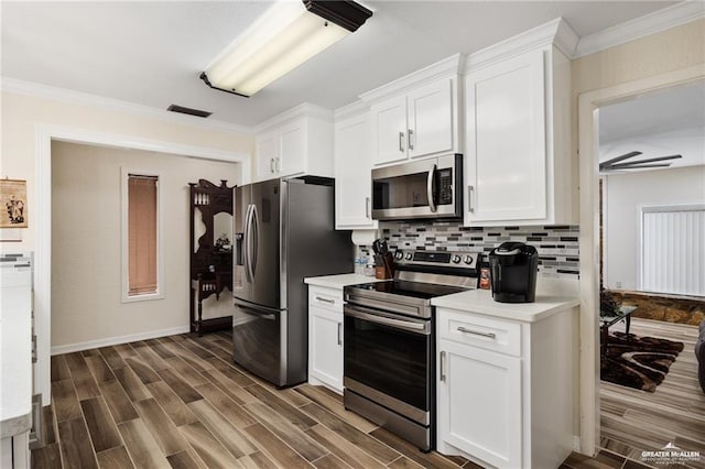 kitchen featuring stainless steel appliances, wood finish floors, light countertops, and decorative backsplash