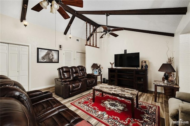 living room featuring a ceiling fan, vaulted ceiling with beams, baseboards, and wood finished floors