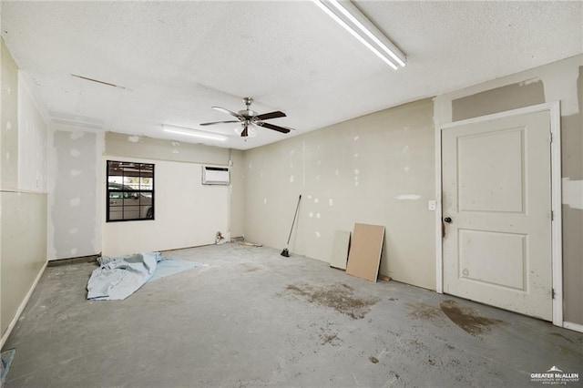 spare room with a wall mounted air conditioner, unfinished concrete flooring, and a textured ceiling