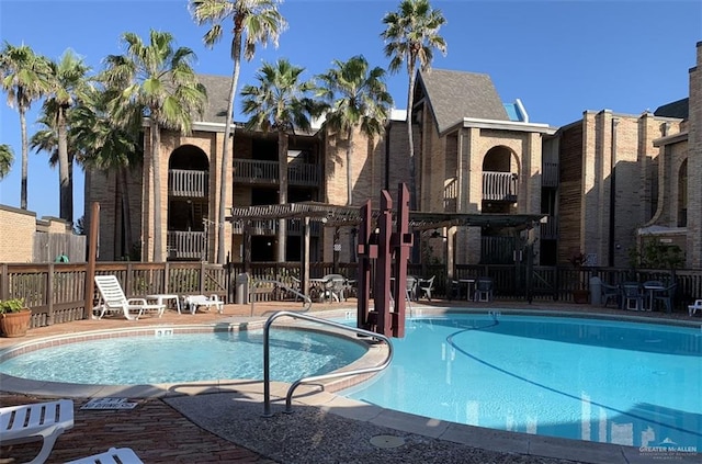 community pool featuring fence, a pergola, and a patio