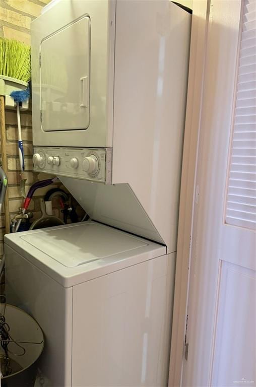 laundry area with stacked washer and dryer and laundry area