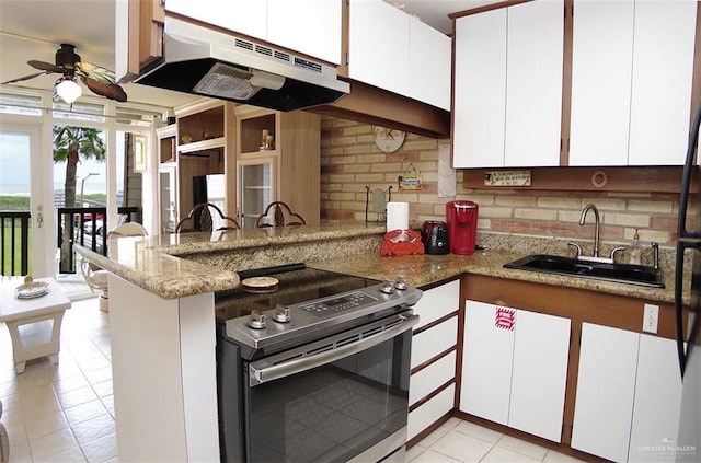 kitchen with a peninsula, a sink, electric range, a ceiling fan, and under cabinet range hood
