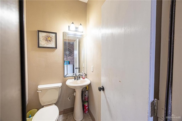 bathroom with toilet and baseboards