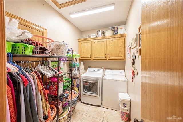 laundry area featuring cabinet space, light tile patterned flooring, and washing machine and clothes dryer
