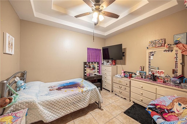 bedroom with a ceiling fan, a tray ceiling, and light tile patterned floors