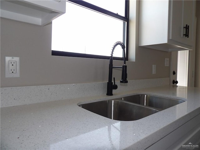 interior details with light stone countertops and sink