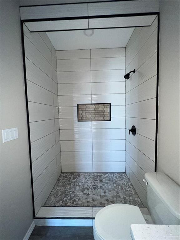 bathroom featuring toilet and tiled shower