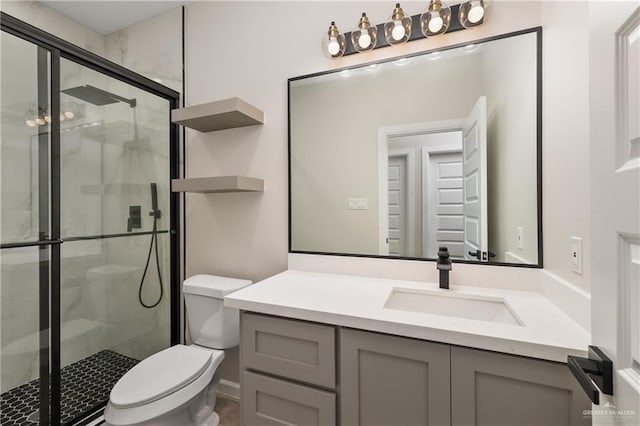 full bathroom featuring a stall shower, vanity, and toilet