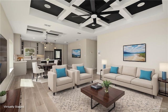 living area featuring wood finish floors, beam ceiling, a notable chandelier, visible vents, and coffered ceiling