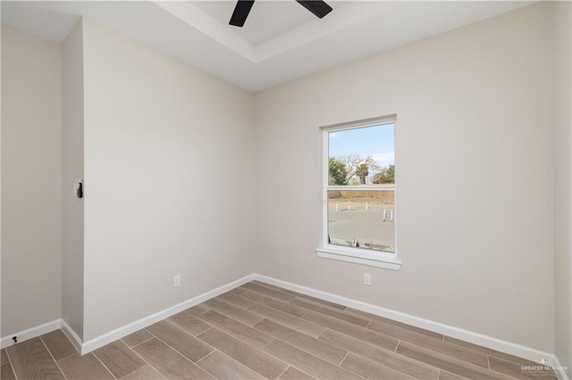 spare room featuring baseboards, a ceiling fan, and wood finish floors