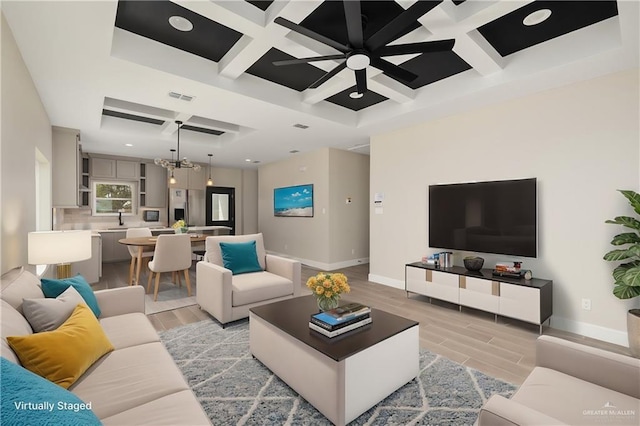 living room with a notable chandelier, baseboards, visible vents, and wood tiled floor