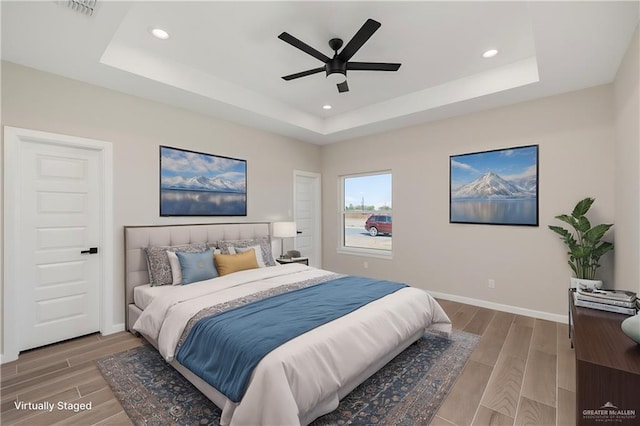 bedroom featuring a tray ceiling and wood tiled floor