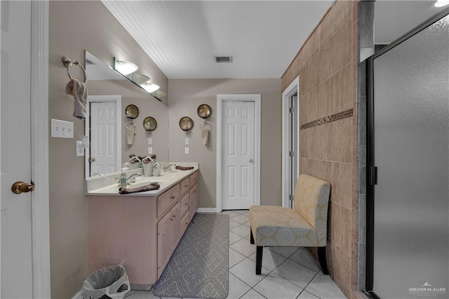 bathroom featuring tile patterned flooring, vanity, a shower with door, and tile walls