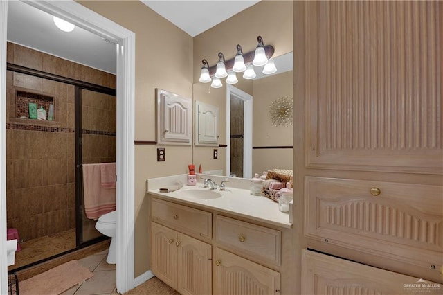 bathroom with tile patterned floors, vanity, toilet, and a shower with shower door