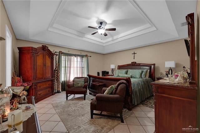 bedroom featuring ceiling fan, light tile patterned floors, and a tray ceiling