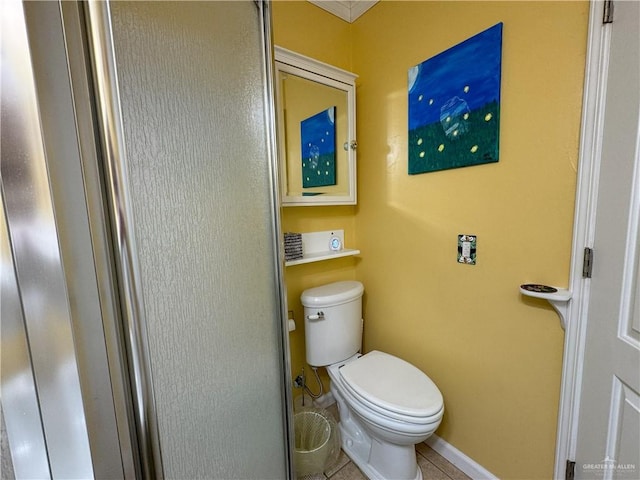 bathroom featuring baseboards, toilet, and tile patterned floors