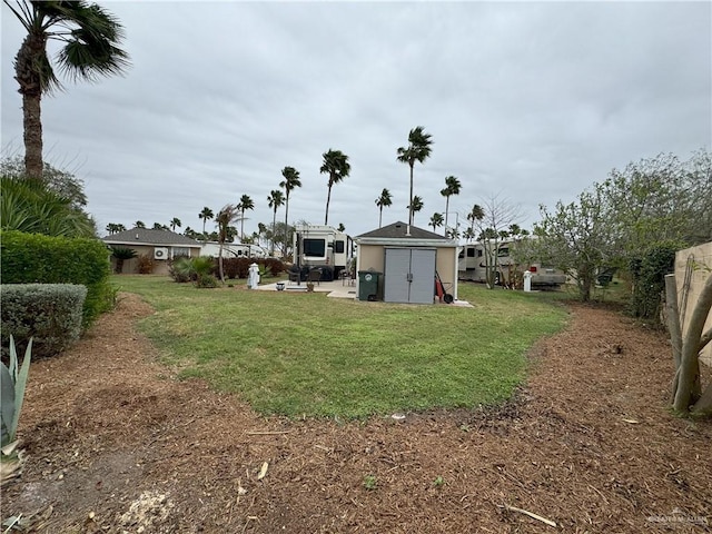 view of yard featuring a storage shed, an outdoor structure, and fence