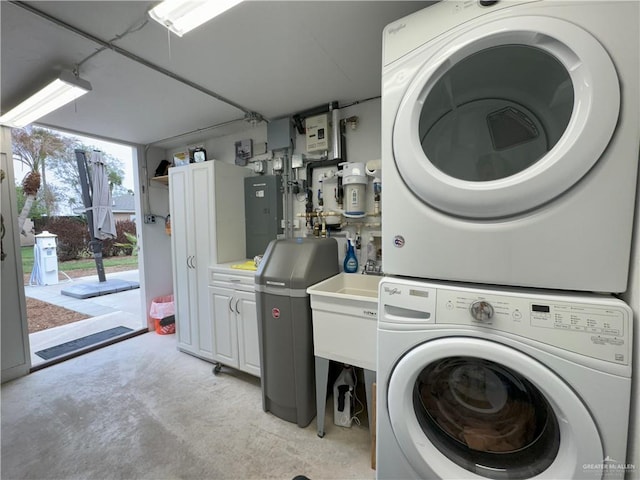 laundry area with stacked washer and clothes dryer and cabinet space