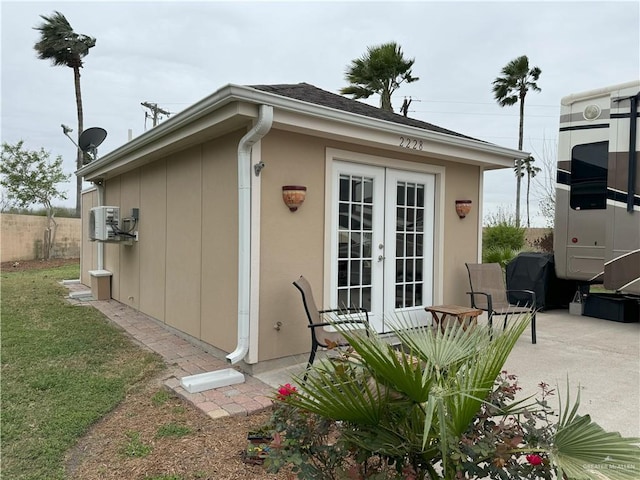 view of outbuilding featuring fence and french doors