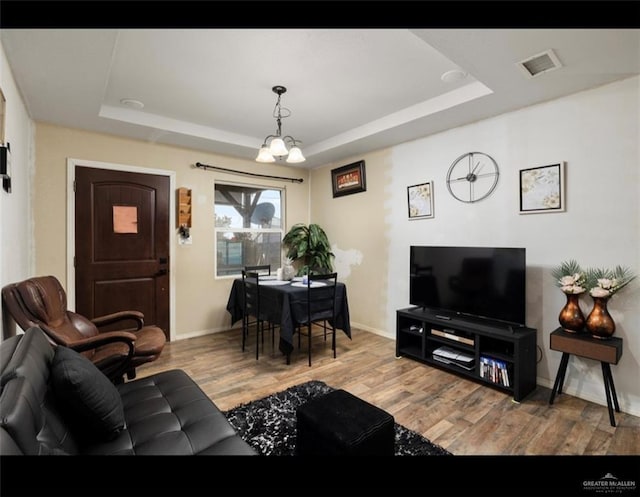 9913 Daniec St, Edinburg, TX 78542 - living area with a tray ceiling, wood finished floors, a chandelier, and baseboards