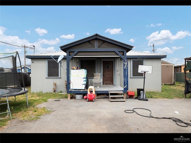 9913 Daniec St, Edinburg, TX 78542 - view of front facade featuring a trampoline, stucco siding, and metal roof