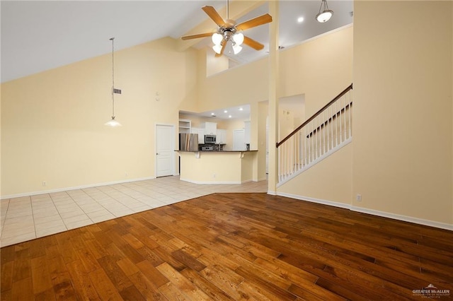 4012 Toronto Ave, Mcallen, TX 78503 - unfurnished living room featuring hardwood / wood-style floors, a ceiling fan, high vaulted ceiling, baseboards, and stairway