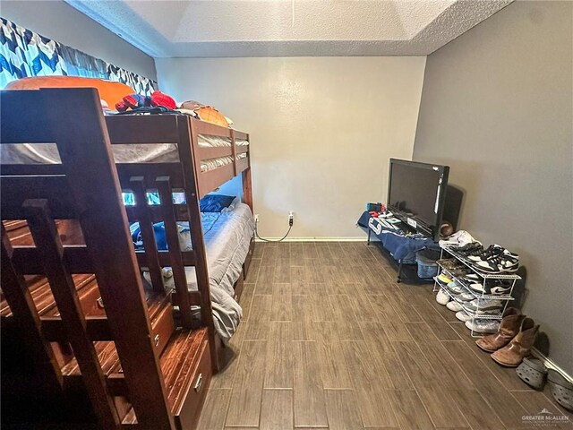 bedroom featuring baseboards and wood finish floors