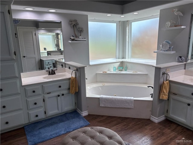 bathroom featuring hardwood / wood-style flooring, a tub to relax in, and vanity