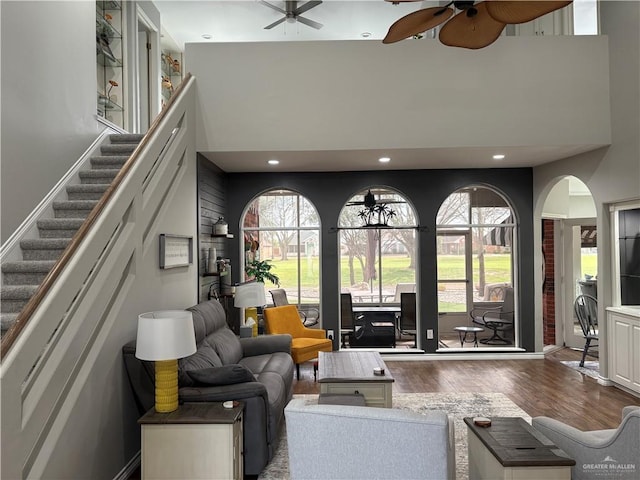 living room featuring a high ceiling, ceiling fan, a wealth of natural light, and light hardwood / wood-style floors