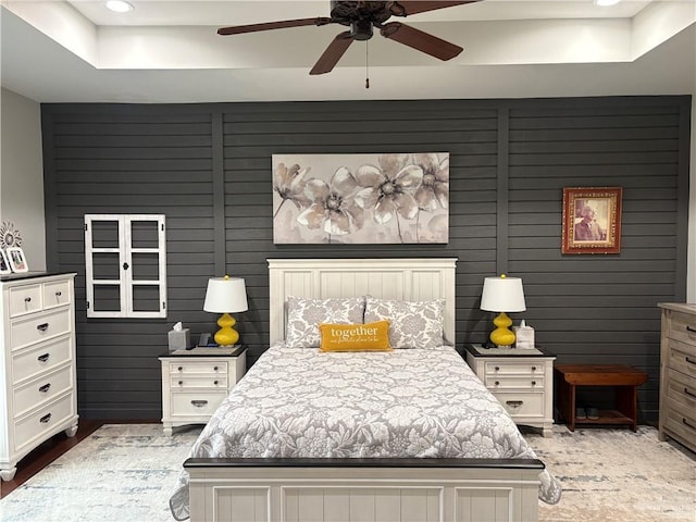 bedroom featuring a raised ceiling and ceiling fan