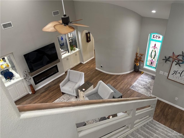 living room with ceiling fan and dark hardwood / wood-style flooring