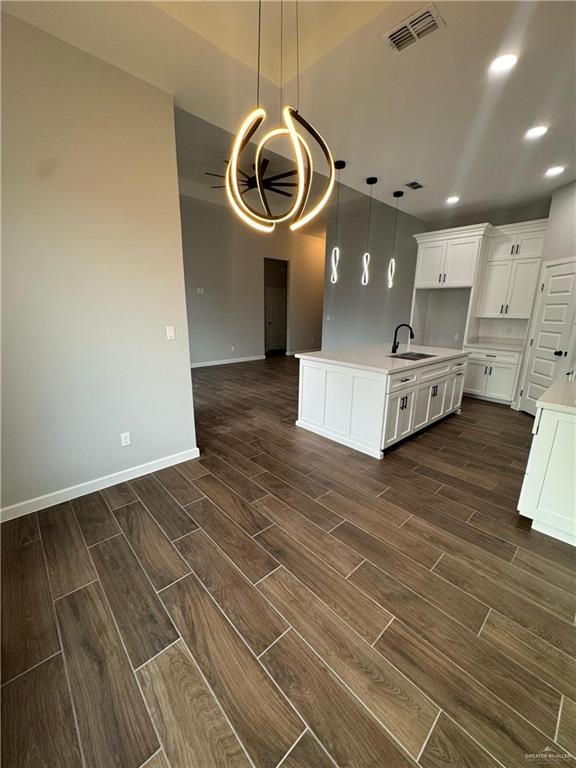 kitchen with visible vents, light countertops, open floor plan, and wood tiled floor