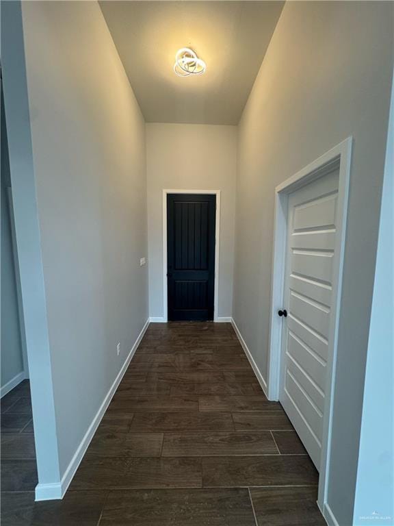 doorway to outside with dark wood-style floors and baseboards