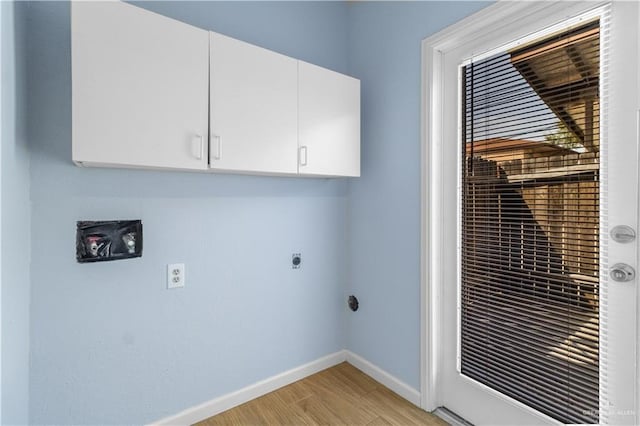 clothes washing area with light wood-type flooring, cabinet space, hookup for an electric dryer, and baseboards