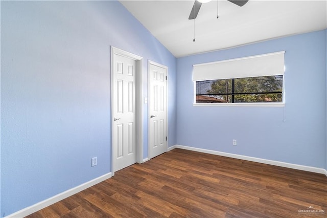 spare room featuring a ceiling fan, baseboards, vaulted ceiling, and wood finished floors