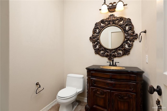 bathroom with baseboards, vanity, and toilet