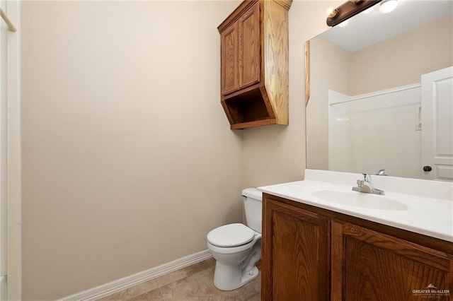 bathroom with toilet, baseboards, walk in shower, and vanity