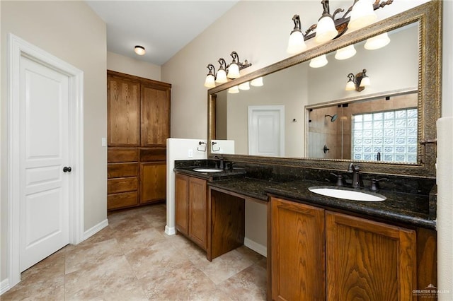 bathroom featuring a stall shower, a sink, baseboards, and double vanity