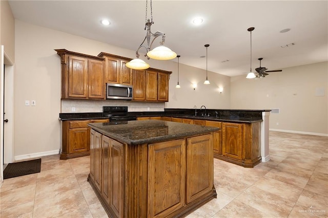 kitchen with electric range, tasteful backsplash, a kitchen island, stainless steel microwave, and a peninsula