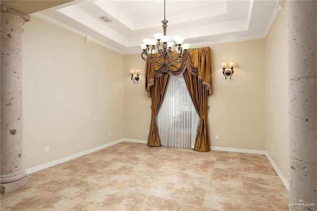 empty room with decorative columns, visible vents, a raised ceiling, and baseboards