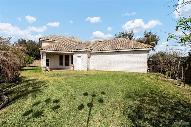 back of house with a patio, a fenced backyard, a tile roof, a ceiling fan, and a yard