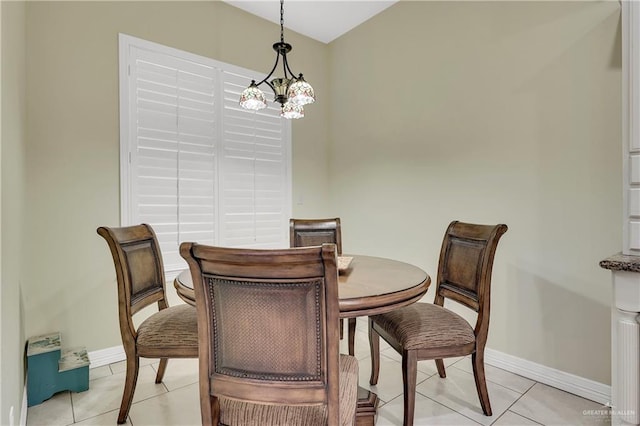 dining space with light tile patterned flooring and a chandelier